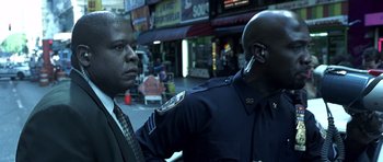 Movie still from “Phone Booth” (2002), directed by Joel Schumacher – Two police officers standing next to each other on the street; Close Up shot, Low angle