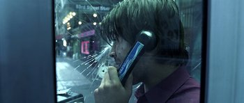 Movie still from “Phone Booth” (2002), directed by Joel Schumacher – A man is on a cell phone in front of a shattered window; Extreme Close Up shot, Overhead angle
