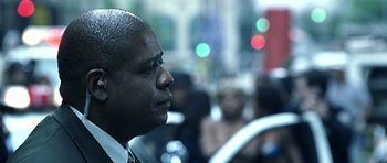 Movie still from “Phone Booth” (2002), directed by Joel Schumacher – A man that is standing in the street; Close Up shot, Over the shoulder angle
