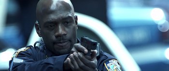 Movie still from “Phone Booth” (2002), directed by Joel Schumacher – A police officer is holding a cell phone in his hand; Close Up shot, Low angle