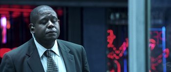 Movie still from “Phone Booth” (2002), directed by Joel Schumacher – A man in a suit and tie standing in front of a building; Close Up shot, Low angle