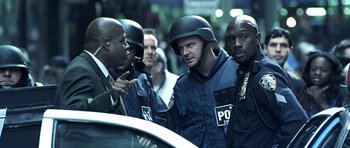 Movie still from “Phone Booth” (2002), directed by Joel Schumacher – A group of men in police uniforms standing next to each other; Medium shot, Over the shoulder angle