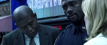 Movie still from “Phone Booth” (2002), directed by Joel Schumacher – Two men in suits are sitting next to each other in front of a neon sign; Close Up shot, Over the shoulder angle