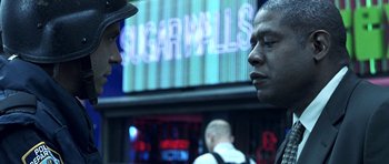 Movie still from “Phone Booth” (2002), directed by Joel Schumacher – Two men are talking in front of a large screen; Close Up shot, Over the shoulder angle