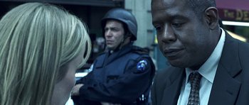 Movie still from “Phone Booth” (2002), directed by Joel Schumacher – Two men and a woman are standing in front of a police officer; Close Up shot, Over the shoulder angle