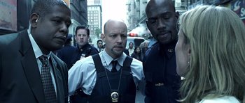 Movie still from “Phone Booth” (2002), directed by Joel Schumacher – A group of police officers walking down a street; Medium shot, Low angle