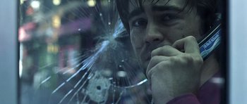 Movie still from “Phone Booth” (2002), directed by Joel Schumacher – A person looking through a broken glass window; Close Up shot, Over the shoulder angle