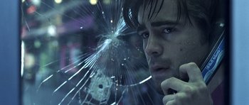 Movie still from “Phone Booth” (2002), directed by Joel Schumacher – A man looking through a broken window glass; Close Up shot, Low angle