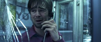 Movie still from “Phone Booth” (2002), directed by Joel Schumacher – A man talking on a phone while standing next to a bus; Close Up shot, Low angle