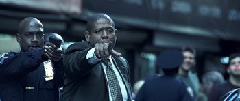 Movie still from “Phone Booth” (2002), directed by Joel Schumacher – A man in a suit and tie pointing at the camera; Medium shot, Low angle