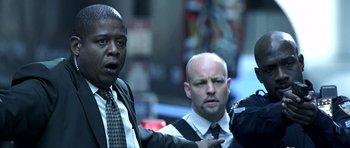 Movie still from “Phone Booth” (2002), directed by Joel Schumacher – A man in a suit and tie standing next to another man in a suit and tie; Close Up shot, Over the shoulder angle