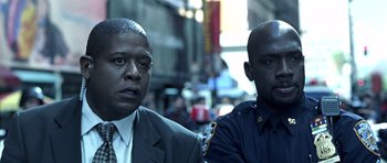 Movie still from “Phone Booth” (2002), directed by Joel Schumacher – Two men in suits are standing next to each other in the street; Close Up shot, Low angle