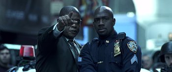 Movie still from “Phone Booth” (2002), directed by Joel Schumacher – Two police officers standing next to each other; Medium shot, Low angle