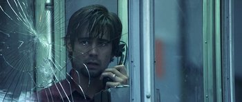 Movie still from “Phone Booth” (2002), directed by Joel Schumacher – A man with headphones is talking on a cell phone; Close Up shot, Low angle