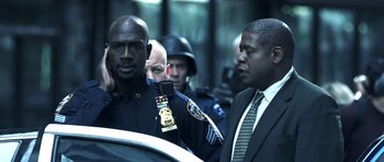 Movie still from “Phone Booth” (2002), directed by Joel Schumacher – A group of men standing next to each other; Medium shot, Over the shoulder angle