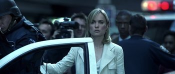 Movie still from “Phone Booth” (2002), directed by Joel Schumacher – A woman standing next to a car in front of a crowd; Close Up shot, Over the shoulder angle