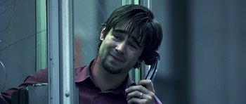 Movie still from “Phone Booth” (2002), directed by Joel Schumacher – A man holding a cell phone up to his ear; Close Up shot, Low angle