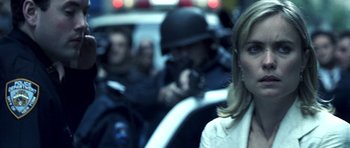 Movie still from “Phone Booth” (2002), directed by Joel Schumacher – A woman in a white dress is in the back of a cop car; Close Up shot, Over the shoulder angle
