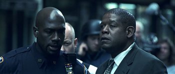 Movie still from “Phone Booth” (2002), directed by Joel Schumacher – Two men in suits and ties looking at a cell phone; Close Up shot, Over the shoulder angle