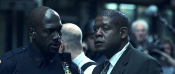 Movie still from “Phone Booth” (2002), directed by Joel Schumacher – A man in a suit and tie next to another man in a suit and tie; Close Up shot, Over the shoulder angle