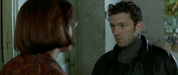 Movie still from “The Crimson Rivers” (2000), directed by Mathieu Kassovitz – A man and a woman looking at one another in front of a wall; Close Up shot, Over the shoulder angle
