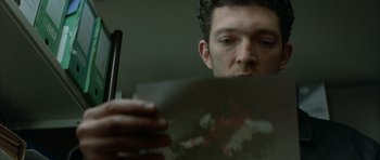Movie still from “The Crimson Rivers” (2000), directed by Mathieu Kassovitz – A person looking at a piece of paper; Close Up shot, Overhead angle