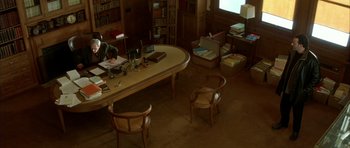 Movie still from “The Crimson Rivers” (2000), directed by Mathieu Kassovitz – A room with a desk and a lot of chairs; Wide shot, High angle