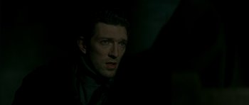 Movie still from “The Crimson Rivers” (2000), directed by Mathieu Kassovitz – A person wearing a suit and tie; Close Up shot, Over the shoulder angle