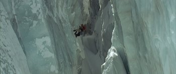 Movie still from “The Crimson Rivers” (2000), directed by Mathieu Kassovitz – A man is climbing up the side of an icy mountain; Extreme Wide shot, Overhead angle