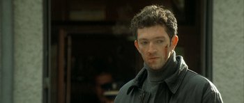 Movie still from “The Crimson Rivers” (2000), directed by Mathieu Kassovitz – A person wearing a jacket; Close Up shot, Over the shoulder angle