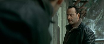 Movie still from “The Crimson Rivers” (2000), directed by Mathieu Kassovitz – A person standing next to a wall; Close Up shot, Over the shoulder angle