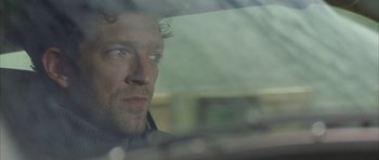 Movie still from “The Crimson Rivers” (2000), directed by Mathieu Kassovitz – A person looking out a car window; Close Up shot, Over the shoulder angle