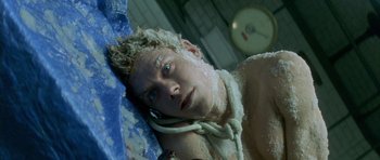 Movie still from “The Crimson Rivers” (2000), directed by Mathieu Kassovitz – A young man is covered in ice and snow; Close Up shot, Overhead angle