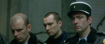 Movie still from “The Crimson Rivers” (2000), directed by Mathieu Kassovitz – A group of men standing next to each other; Close Up shot, Low angle