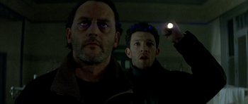 Movie still from “The Crimson Rivers” (2000), directed by Mathieu Kassovitz – Two men are standing next to each other in the dark; Close Up shot, Low angle