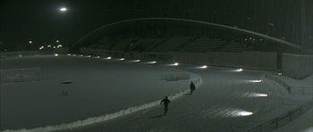 Movie still from “The Crimson Rivers” (2000), directed by Mathieu Kassovitz – Two skiers are going down a slope at night; Extreme Wide shot, High angle