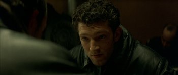 Movie still from “The Crimson Rivers” (2000), directed by Mathieu Kassovitz – A person with curly hair; Close Up shot, Over the shoulder angle