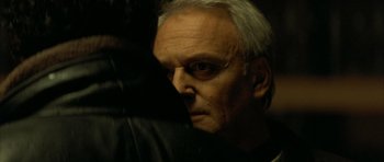 Movie still from “The Crimson Rivers” (2000), directed by Mathieu Kassovitz – An older man with white hair looking into the distance; Close Up shot, Over the shoulder angle