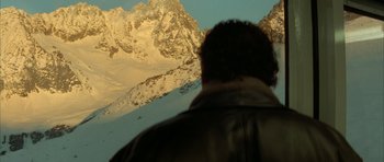 Movie still from “The Crimson Rivers” (2000), directed by Mathieu Kassovitz – A man looking out over a snowy mountain range; Extreme Wide shot, Low angle