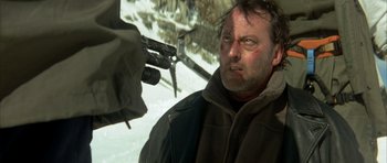 Movie still from “The Crimson Rivers” (2000), directed by Mathieu Kassovitz – A man with a gun pointed at him in the snow; Close Up shot, Low angle