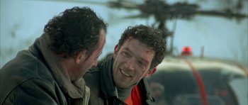 Movie still from “The Crimson Rivers” (2000), directed by Mathieu Kassovitz – A man with blood on his face is smiling for the camera; Close Up shot, Over the shoulder angle