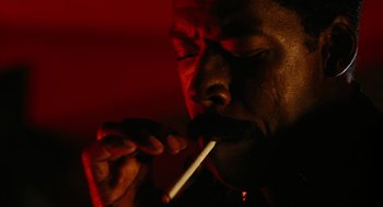Movie still from “The Crow” (1994), directed by Alex Proyas – A man is smoking a cigarette in the dark; Extreme Close Up shot, High angle
