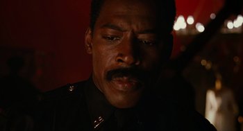 Movie still from “The Crow” (1994), directed by Alex Proyas – A person wearing a police uniform; Close Up shot, Low angle