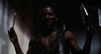 Movie still from “The Crow” (1994), directed by Alex Proyas – A man with dreads is smiling for the camera; Close Up shot, Low angle