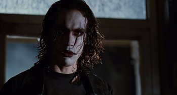 Movie still from “The Crow” (1994), directed by Alex Proyas – A person wearing a black shirt; Close Up shot, Low angle