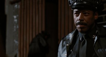 Movie still from “The Crow” (1994), directed by Alex Proyas – A man wearing a leather jacket and hat; Close Up shot, Low angle