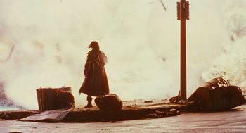 Movie still from “The Crow” (1994), directed by Alex Proyas – A woman standing on the side of a road; Wide shot, Low angle