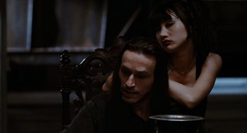 Movie still from “The Crow” (1994), directed by Alex Proyas – A man and a woman sitting next to each other on a chair; Close Up shot, Over the shoulder angle