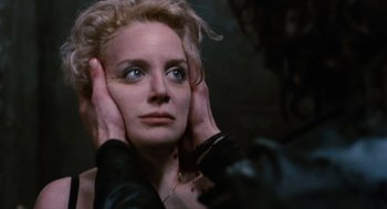 Movie still from “The Crow” (1994), directed by Alex Proyas – A person holding their hands up to their ears; Close Up shot, Over the shoulder angle