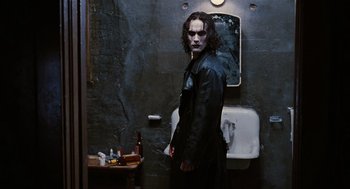Movie still from “The Crow” (1994), directed by Alex Proyas – A man standing in front of a sink in a bathroom; Medium shot, Low angle